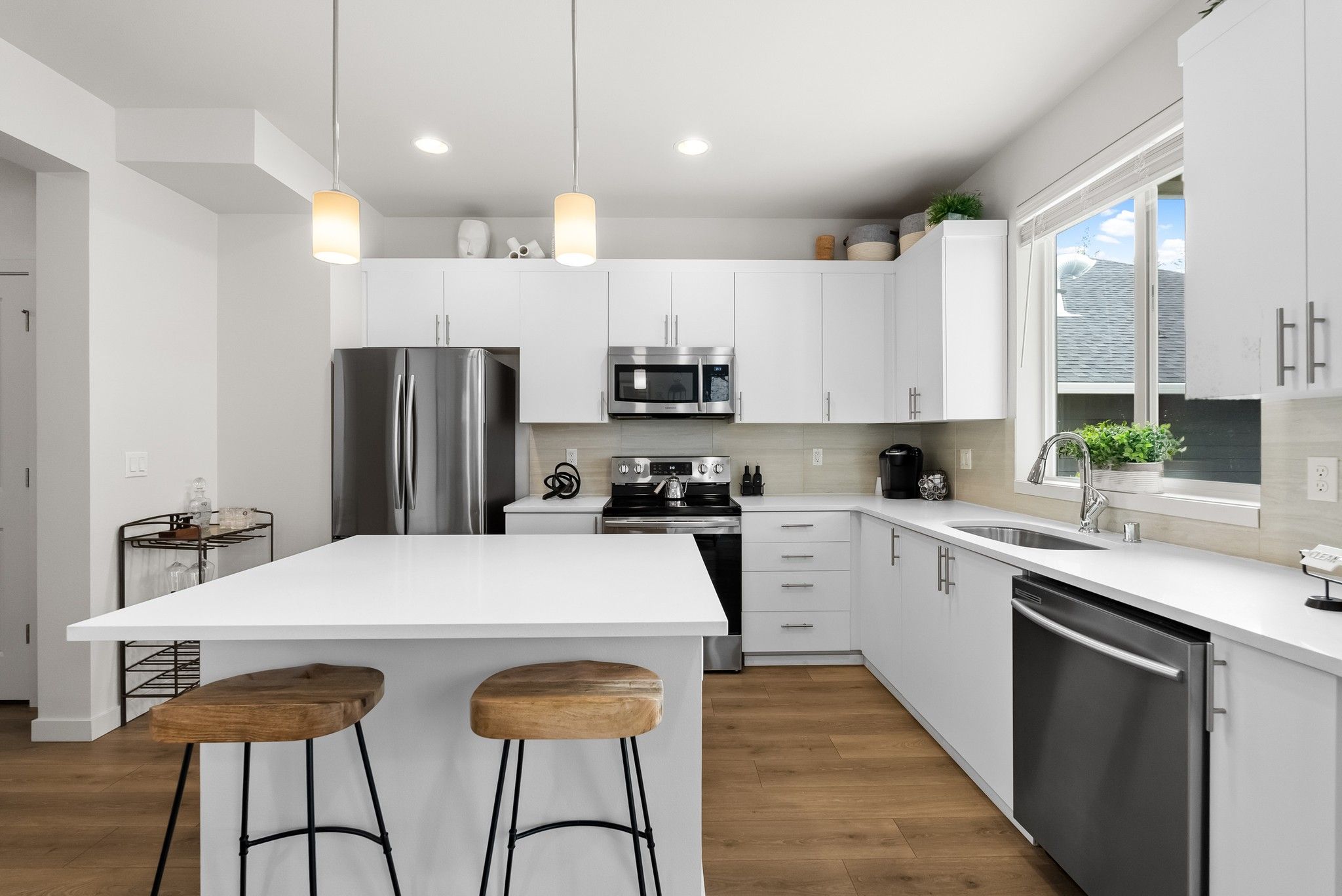 Skansie Pointe apartment interior of beautiful kitchen with stainless steel appliances, a kitchen island, and pendant lighting